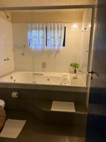 a bathroom with a bath tub and a shower at Pousada A Casa da Fazenda in Santo Antônio do Pinhal