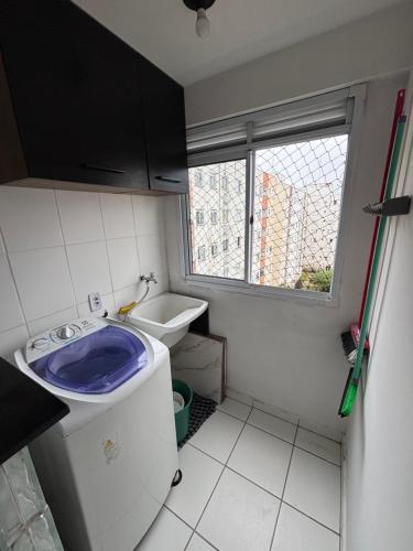 a small bathroom with a toilet and a window at Lazer Oceanos in São Vicente