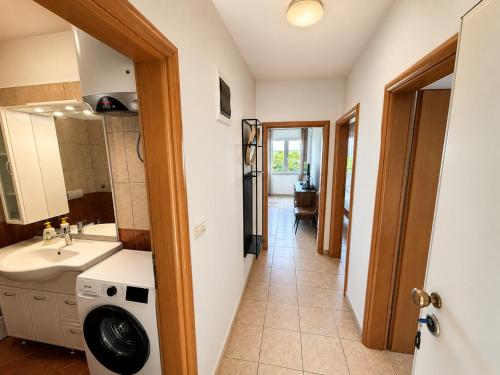 a bathroom with a sink and a washing machine at Apartman with sea view KAVALA- Pašman, Kraj in Kraj