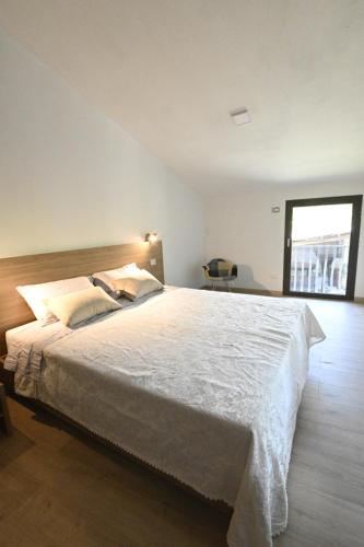 a large white bed in a room with a window at Corte Nascimben in Marano di Valpolicella