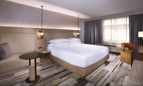a bedroom with a large white bed and a desk at The Paramount Hotel in Seattle