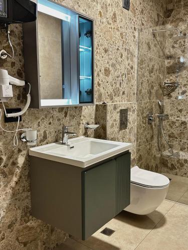a bathroom with a sink and a toilet and a mirror at Casa Mila apartments & bungalows in Ulcinj