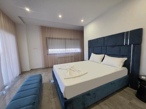 a bedroom with a large bed and a blue couch at Villa Sunrise in Hammamet