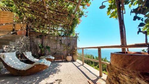 a patio with chairs and the ocean in the background at Sea Side Solandra in Praiano