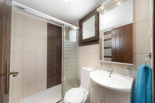 a bathroom with a toilet and a sink and a shower at Villa Areti by Villa Plus in Spiliá