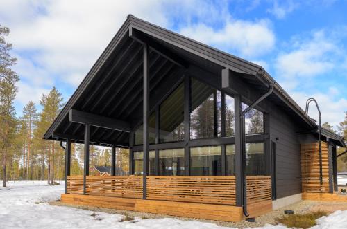 a house with a black roof in the snow at Villa Liemu, Winter season included 2 lift tickets in Äkäslompolo