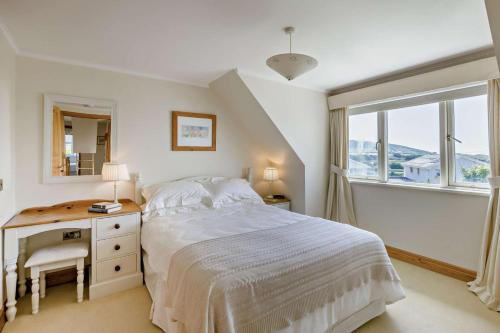 a bedroom with a bed and a desk and a window at 5 Bed in Croyde oc-bonac in Croyde