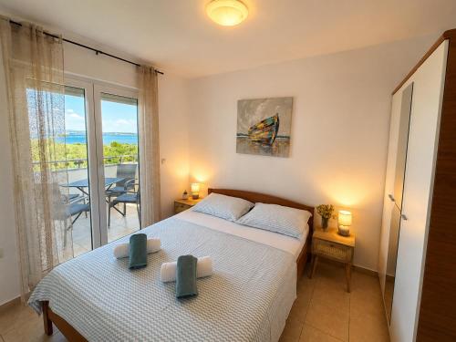 a bedroom with a bed and a view of the ocean at Apartman with sea view KAVALA- Pašman, Kraj in Kraj