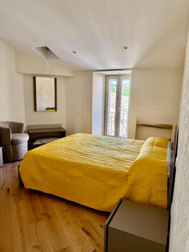 a bedroom with a large bed with a yellow bedspread at Casa Picicio in Assisi