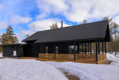 a black house with a black roof in the snow at Villa Liemu, Winter season included 2 lift tickets in Äkäslompolo