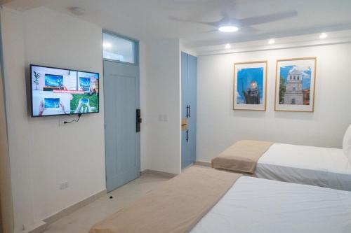a bedroom with two beds and a flat screen tv at Colonial studio with 2 Beds - Patio Español in Santo Domingo
