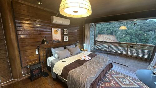 a bedroom with a bed and a large window at Sunrise in Domingos Martins