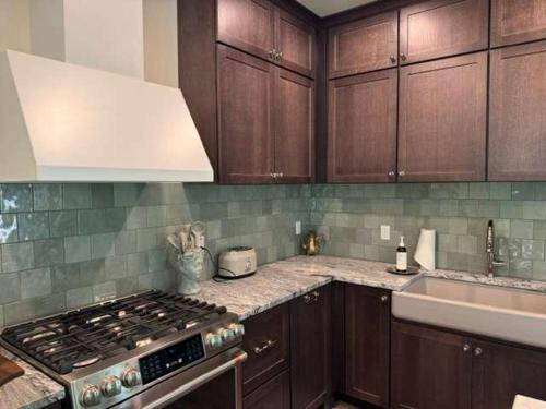 a kitchen with wooden cabinets and a stove top oven at Maison Foxglove - Petite Acres Chateau in New Buffalo