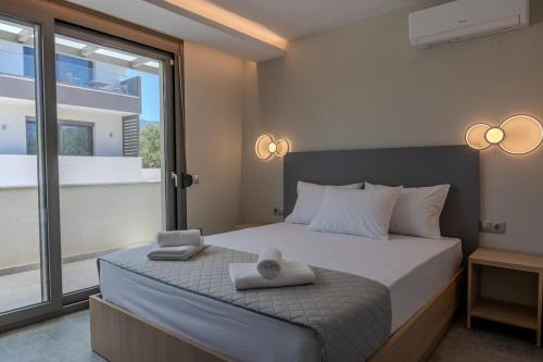 a bedroom with a bed with two towels on it at Psarras Deluxe Suites in Limenas
