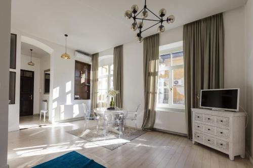 a living room with a television on a dresser at Baross Boutique Apartman in Győr