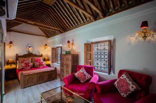 a living room with pink furniture and a bed at Riad el Fenna 1974 in Chefchaouen