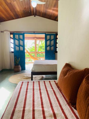 a bedroom with a bed and a large window at Domingas in Ilha de Boipeba