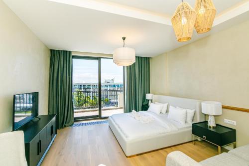 a bedroom with a white bed and a large window at FS The Grand Sea Breeze in Baku