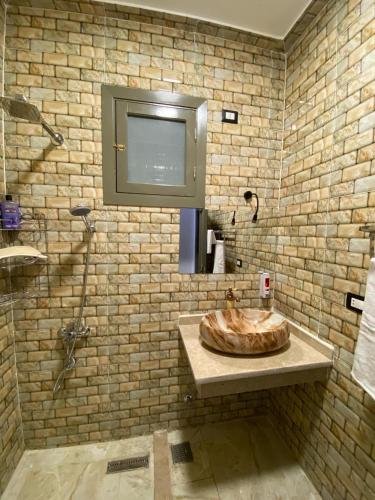 a bathroom with a wooden sink and a brick wall at pure peace hotel in Luxor