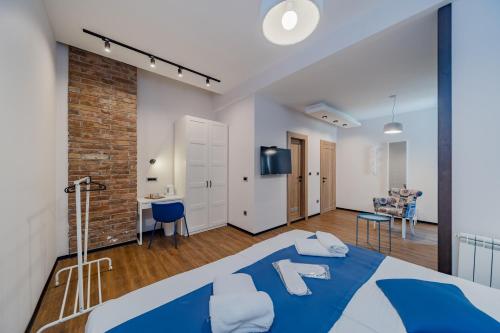 a bedroom with a blue bed and a living room at City Code InJoy RENEW in Belgrade