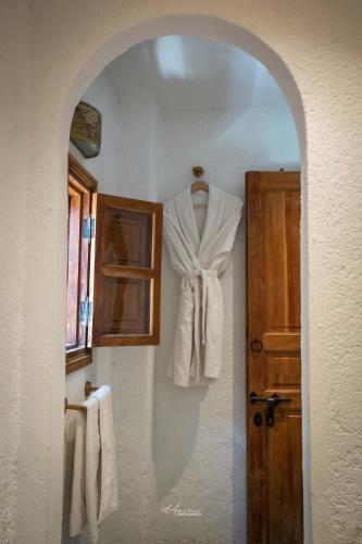 a white robe hanging on a wall next to a door at Riad el Fenna 1974 in Chefchaouen