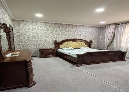 a bedroom with a bed and a dresser and a desk at Marshall in Termiz