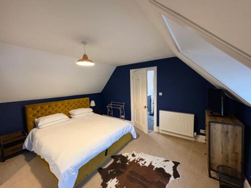 a bedroom with a bed and a blue wall at The townhouse in Stornoway