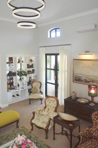 a living room with chairs and a table at Vineyard Views Country House in Riebeek-Kasteel
