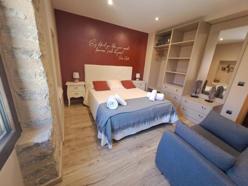 a bedroom with a bed and two blue chairs at Casa Rural Tarayuela in Cantavieja