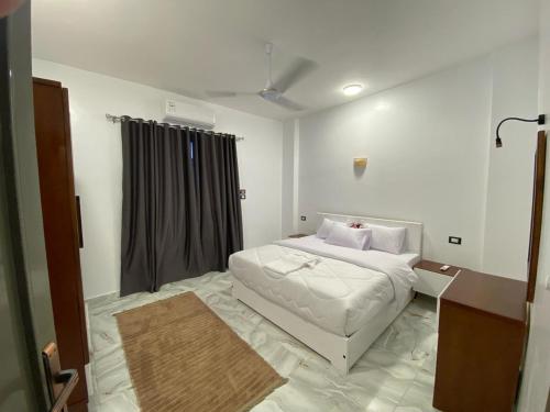 a bedroom with a white bed and a window at pure peace hotel in Luxor