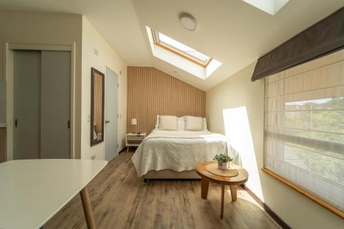 a bedroom with a bed and a window and a table at Studios y Departamentos Nómades del Lago in Puerto Varas