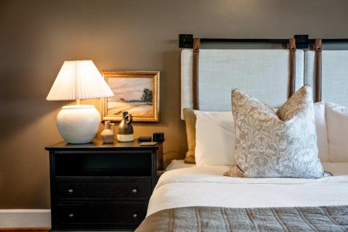 a bedroom with a bed with a lamp on a dresser at Historic Riverview Inn Five in Chattanooga