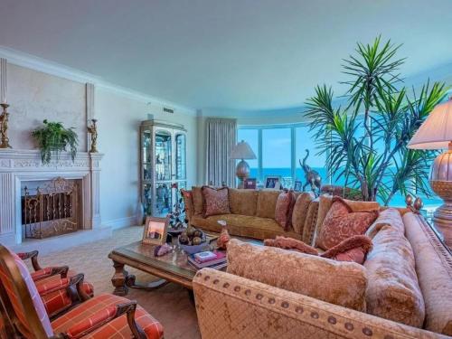 a living room with a couch and a fireplace at Beachfront Elegance Escape in Naples