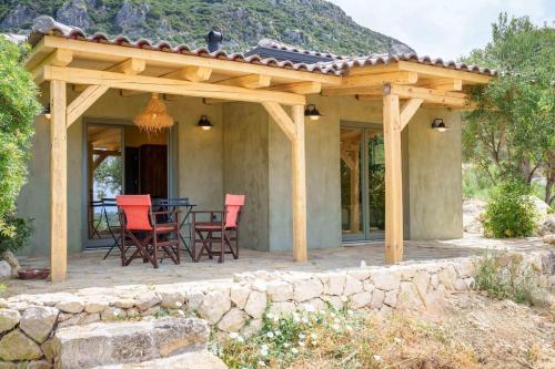 a wooden pavilion with a table and chairs on a patio at Villa Koukounari at Chionata in Atsoupádhes
