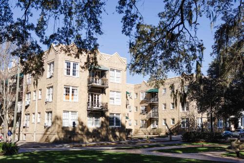 an apartment building with trees in front of it at Oglethorpe Square Historic Apt Central & Walkable in Savannah