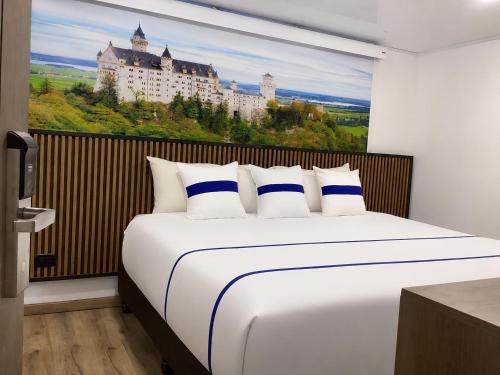 a bedroom with a bed with a painting of a castle at Paramount Hotel in Bogotá
