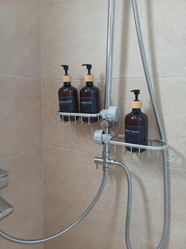 four bottles of soap on a shower shelf in a bathroom at DANAI'S Sea Whisper in Lékhaion