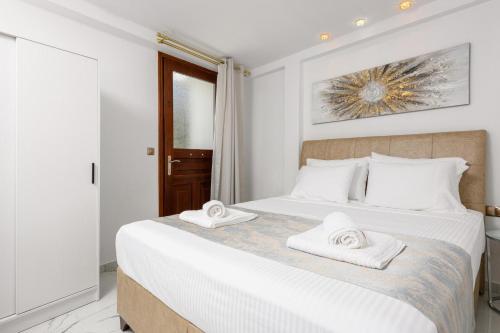 a bedroom with a large white bed with towels on it at Villa Andriana in Panagia
