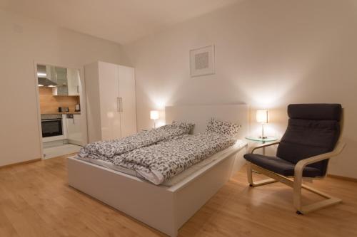 a bedroom with a bed and a chair in it at Modern Apartment at Rathaus in Vienna