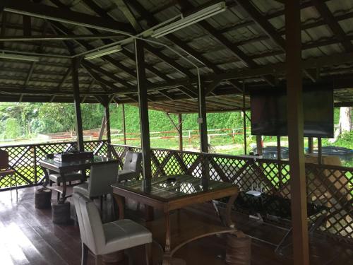 a pavilion with tables and chairs on a wooden floor at Happy Paradise in Kampung Janda Baik