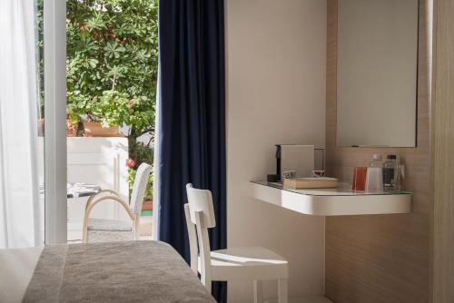 a room with a bed and a table and a window at Hotel Daniele in Lignano Sabbiadoro