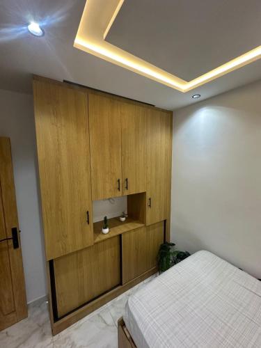 a bedroom with a bed and wooden cabinets at 1-bedroom apartment in Monastir