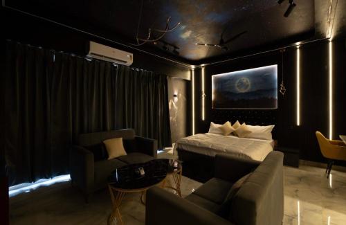 a bedroom with a bed and a couch and a table at Moon escape studio in Ghaziabad