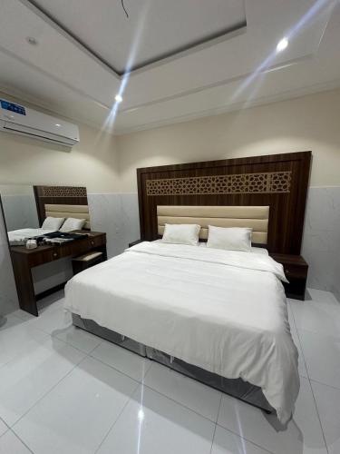a bedroom with a large white bed and a desk at كيان التيسير - حي التيسير in Jeddah