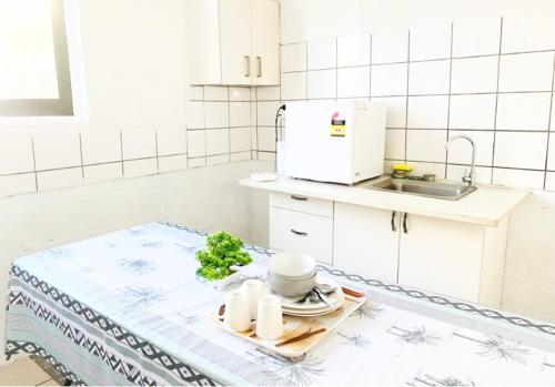 a kitchen with a table with a plate of food at Maota Hotel Apia in Apia