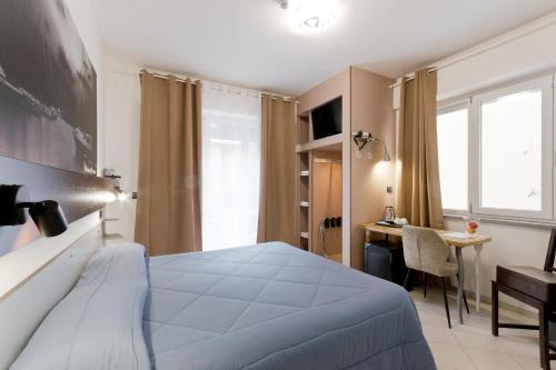a hotel room with a bed and a desk and a window at Bella Pescara B&B in Pescara