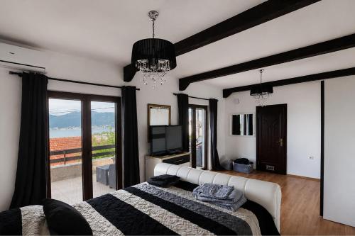 a bedroom with a bed and a television and a window at Villa Bellevue Amazing Sea View 7 Guests in Krašići