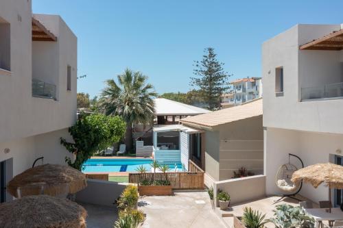 a villa with a swimming pool and two buildings at Nikolas Apartments in Amoudara Herakliou