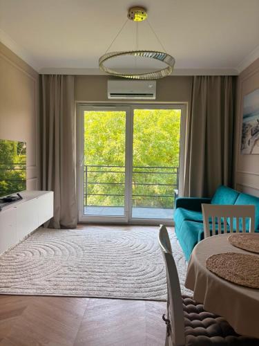 a living room with a large window and a blue couch at Nowoczesny Apartament Tatarska in Przemyśl