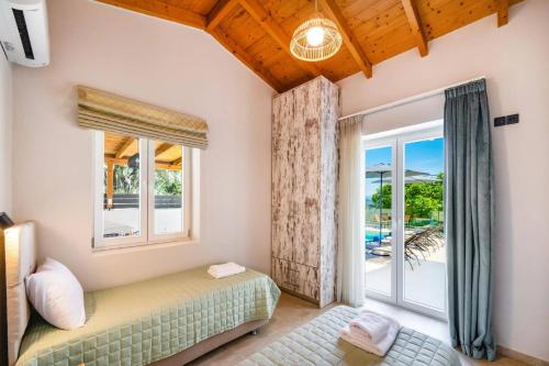 a bedroom with a bed and a window at Villa Mario by Villa Plus in Katokhórion